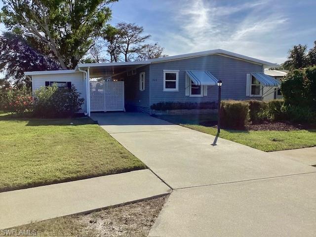 225 Belle Isle Circle Naples, FL 34112 - Photo 24 of 48 a front view of a house with a yard and garage