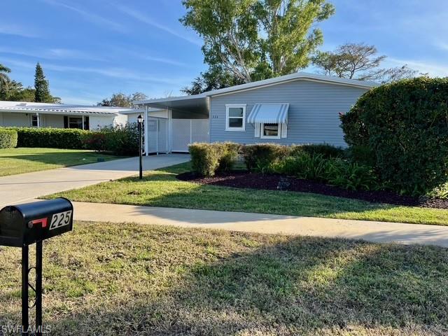 225 Belle Isle Circle Naples, FL 34112 - Photo 3 of 48 a front view of a house with a yard