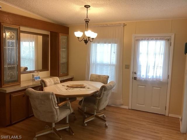 225 Belle Isle Circle Naples, FL 34112 - Photo 8 of 48 a view of a dining room with furniture wooden floor and chandelier