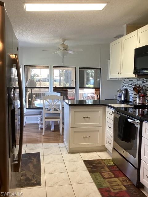 225 Belle Isle Circle Naples, FL 34112 - Photo 10 of 48 a kitchen with stainless steel appliances granite countertop a stove a sink and a microwave