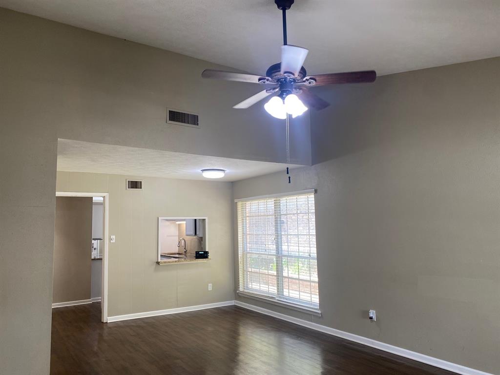 13652 Flagstone Lane Dallas, TX 75240 - Photo 8 of 15 Unfurnished room with a ceiling fan and dark wood-style floors