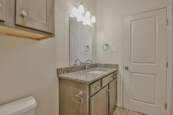 a bathroom with a granite countertop sink and a mirror