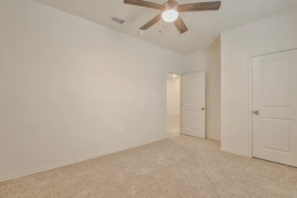 an empty room with chandelier fan