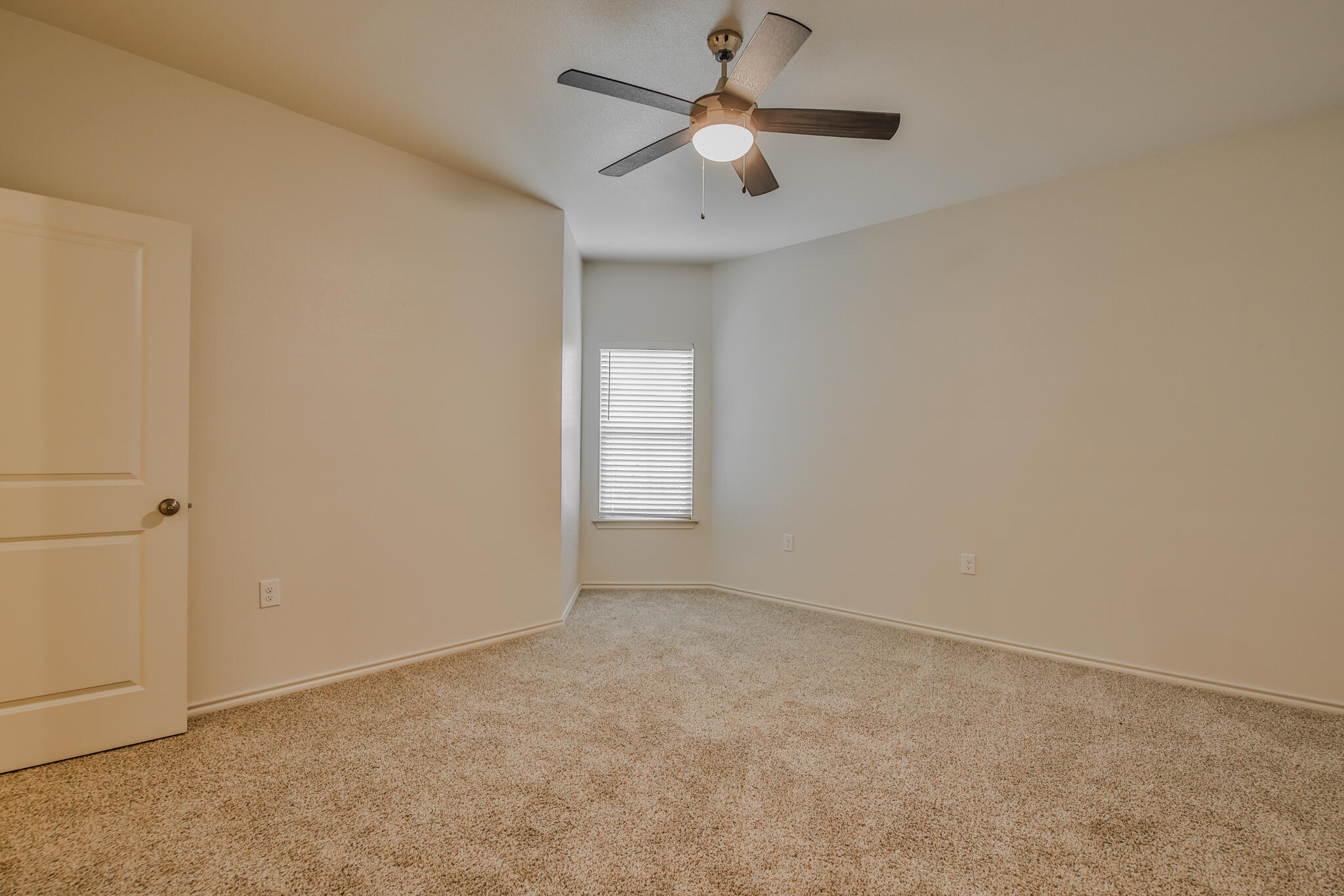 5508 Kemper Street Lubbock, TX 79416 - Photo 19 of 26 an empty room with a window and a fan