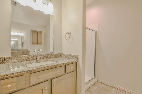 a bathroom with a granite countertop sink and a mirror