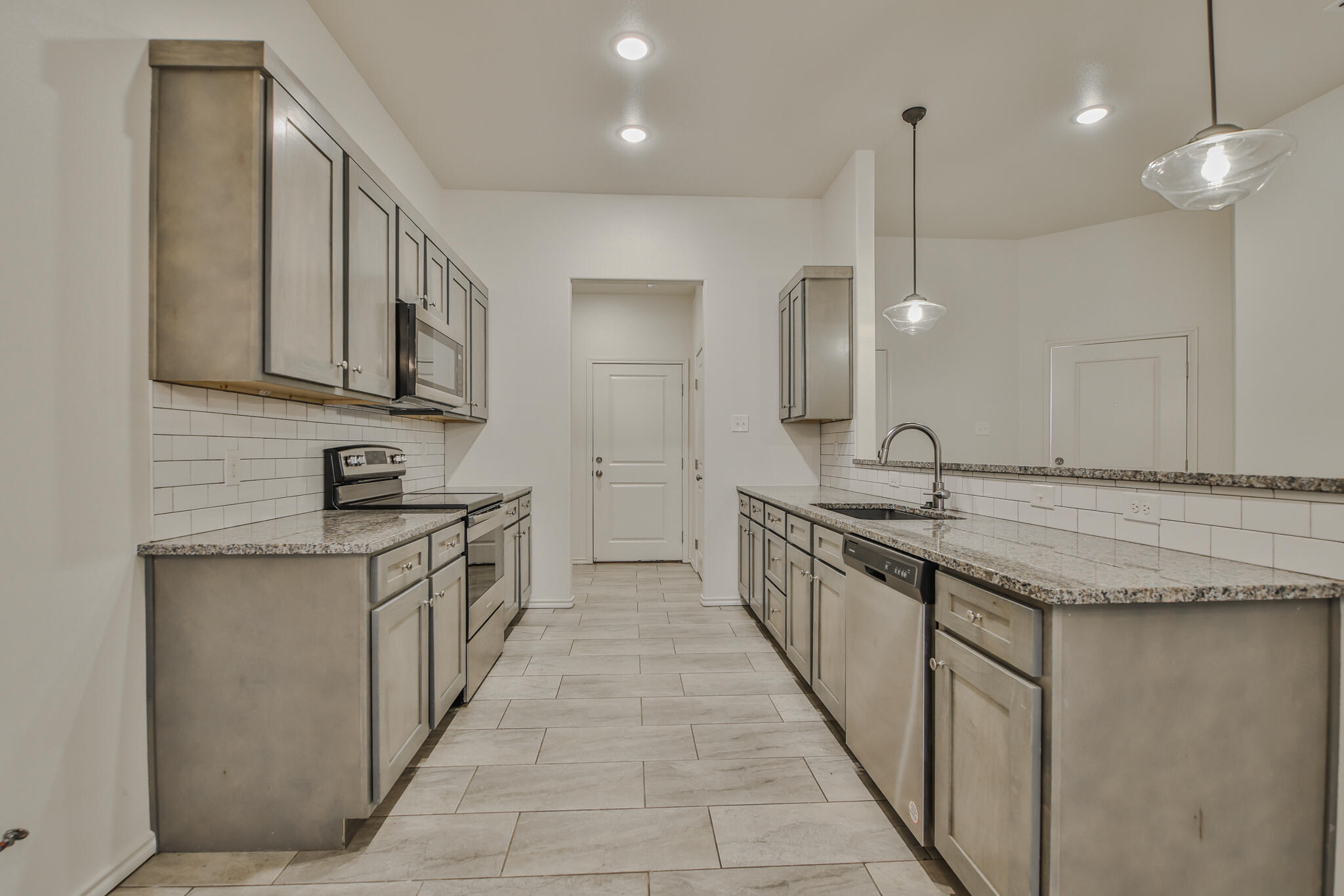 5508 Kemper Street Lubbock, TX 79416 - Photo 5 of 26 a large kitchen with granite countertop a sink and a stove