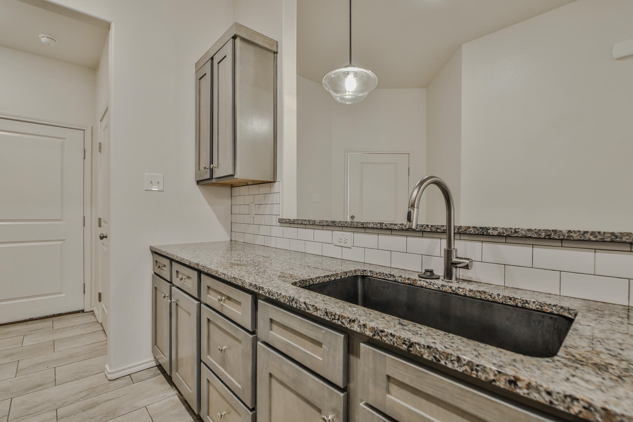 5508 Kemper Street Lubbock, TX 79416 - Photo 8 of 26 a kitchen with a sink and a mirror