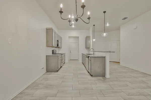 a view of a kitchen with a sink and chandelier