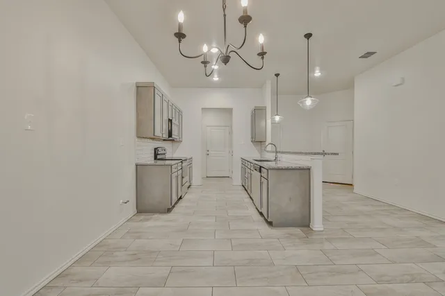a view of a kitchen with a sink and chandelier