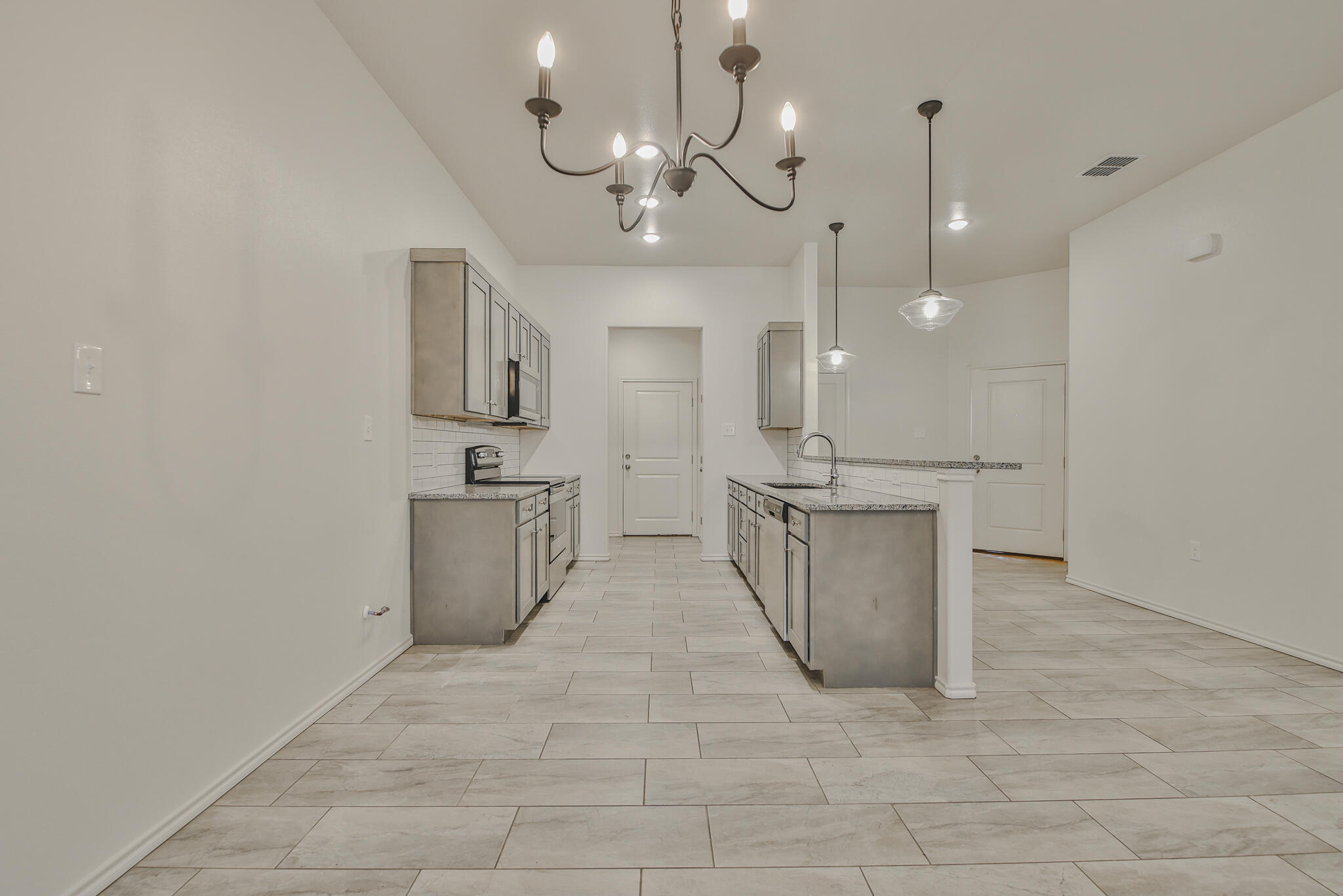 5508 Kemper Street Lubbock, TX 79416 - Photo 9 of 26 a view of a kitchen with a sink and chandelier