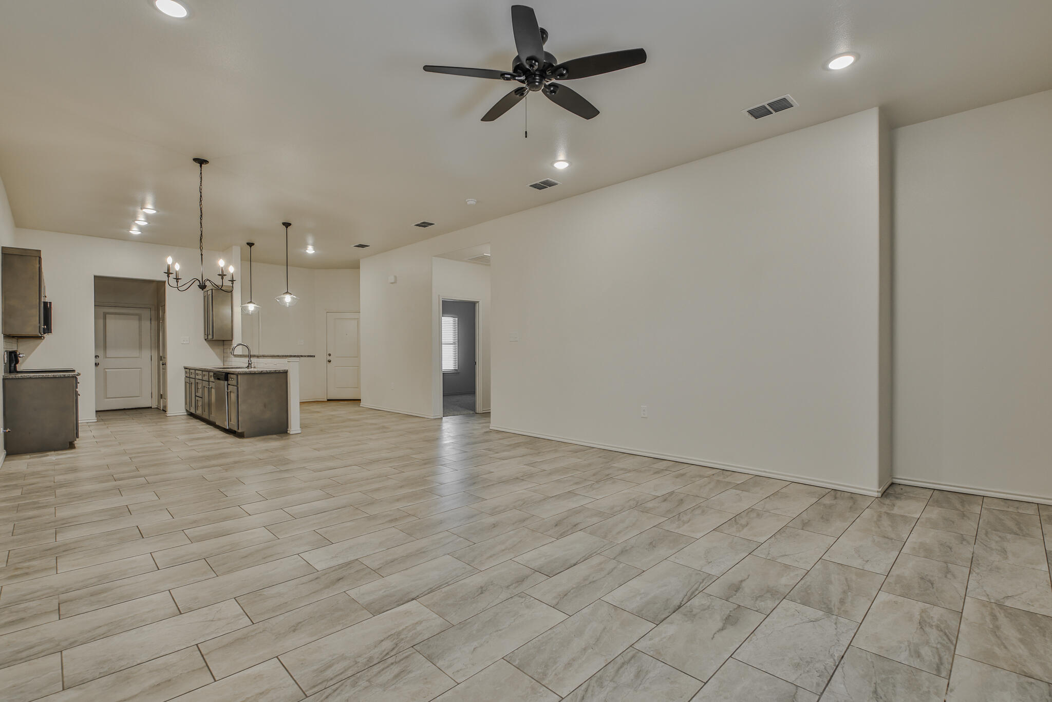5508 Kemper Street Lubbock, TX 79416 - Photo 10 of 26 wooden floor in an empty room with a kitchen