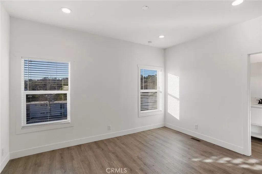 3030 Oceanside, Unit 44 Oceanside, CA 92054 - Photo 19 of 40 an empty room with wooden floor and windows
