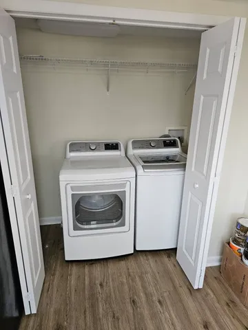 a utility room with wooden floor washer and dryer