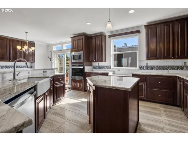 a kitchen with kitchen island granite countertop a sink stove and cabinets