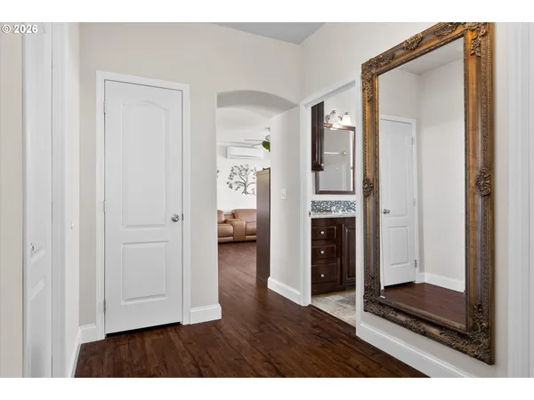 a view of a hallway with wooden floor and closet area