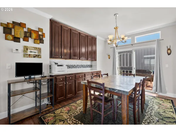 a kitchen with stainless steel appliances kitchen island granite countertop a table chairs and a refrigerator