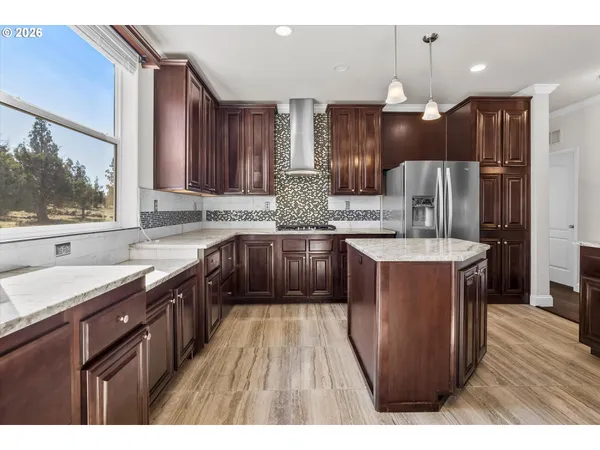 a kitchen with kitchen island granite countertop a sink stove and refrigerator