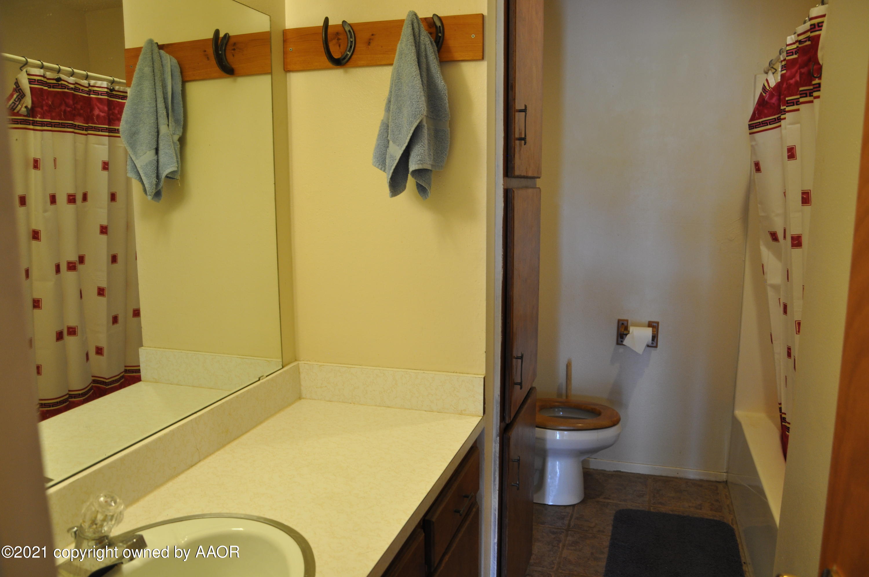 401 Mesa View Miami, TX 79059 - Photo 19 of 26 a bathroom with a granite countertop sink toilet and shower