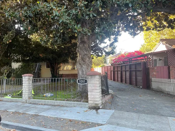 a view of a small yard in front of a house with wooden fence
