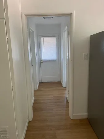 a view of a hallway with wooden floor