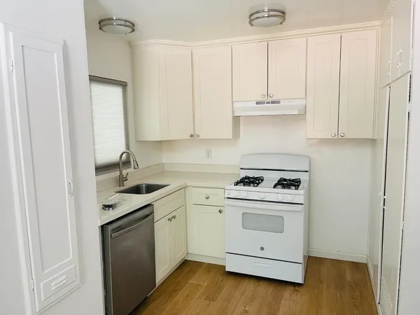 a kitchen with appliances a sink and cabinets