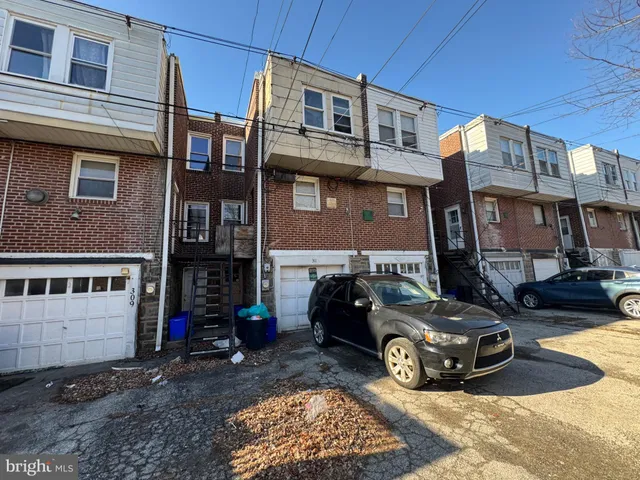 a car parked in front of a brick house