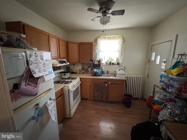 a kitchen that has a lot of cabinets in it and wooden floors