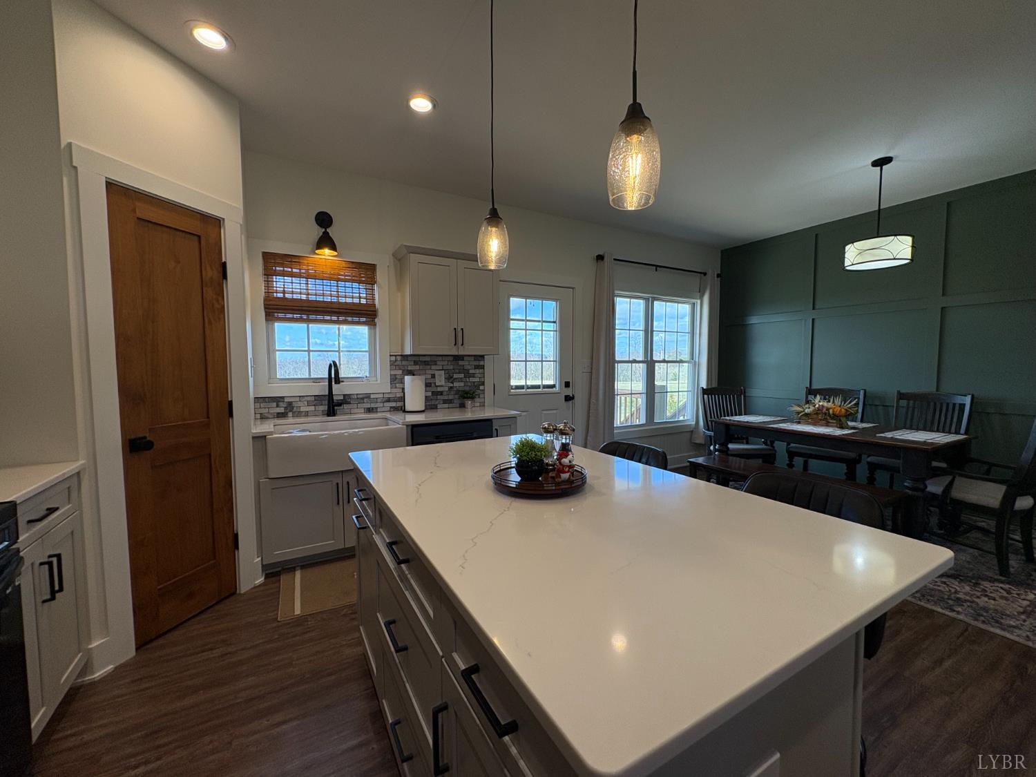2142 Clarks Road Rustburg, VA 24588 - Photo 18 of 70 a kitchen with a stove a sink a kitchen island with chairs and wooden floor