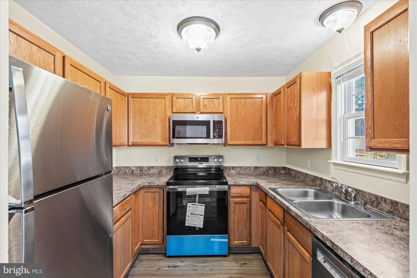 321 3rd Street Colonial Beach, VA 22443 - Photo 15 of 47 a kitchen with stainless steel appliances granite countertop a refrigerator a sink dishwasher a stove top oven a refrigerator and cabinets