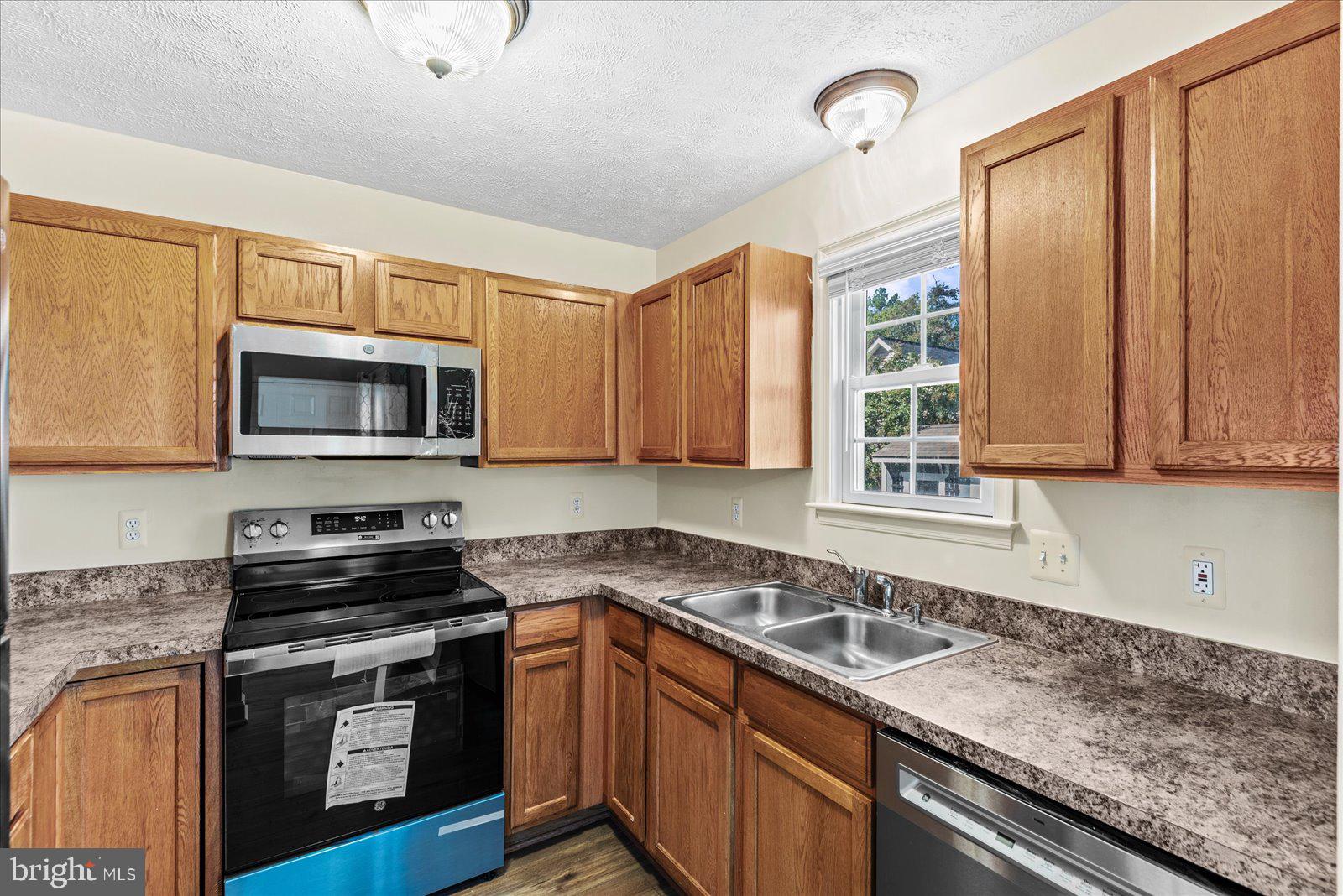 321 3rd Street Colonial Beach, VA 22443 - Photo 16 of 47 a kitchen with stainless steel appliances granite countertop a sink a stove and a microwave