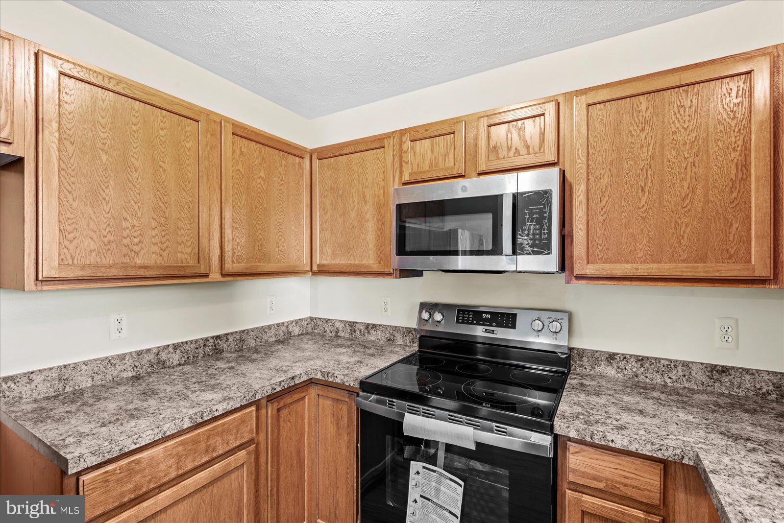 321 3rd Street Colonial Beach, VA 22443 - Photo 18 of 47 a kitchen with stainless steel appliances granite countertop a stove microwave and cabinets
