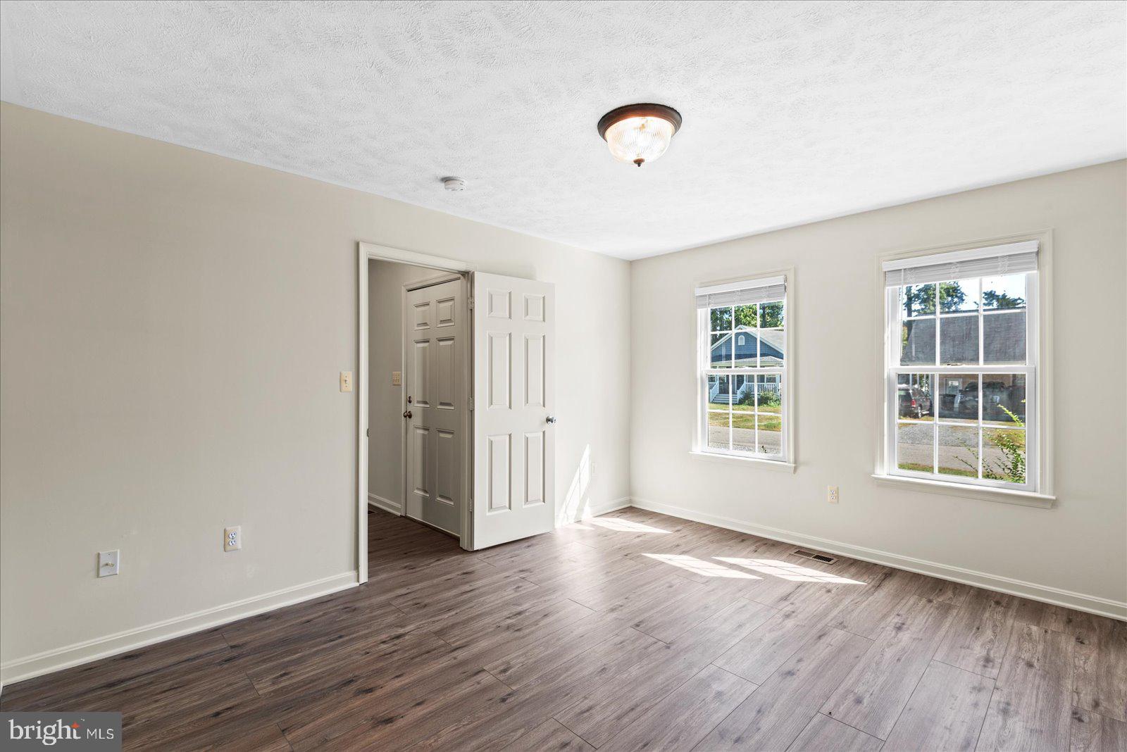 321 3rd Street Colonial Beach, VA 22443 - Photo 21 of 47 an empty room with wooden floor and windows