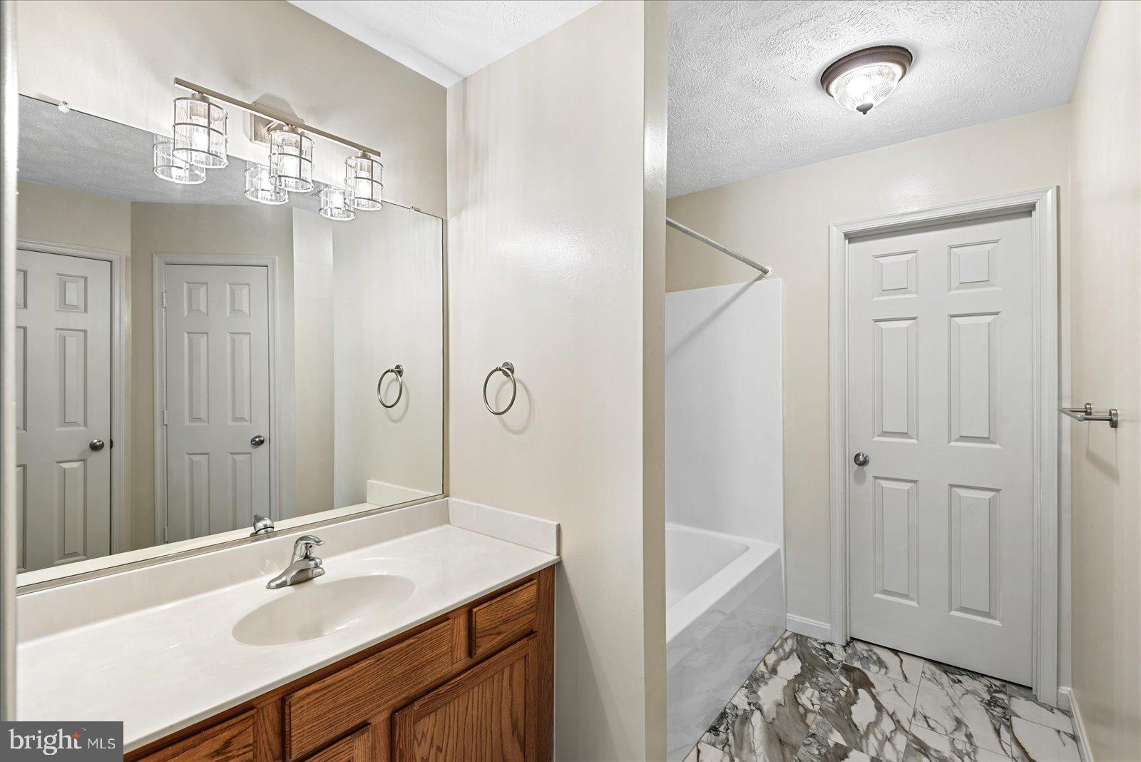 321 3rd Street Colonial Beach, VA 22443 - Photo 26 of 47 a bathroom with a sink shower and a mirror