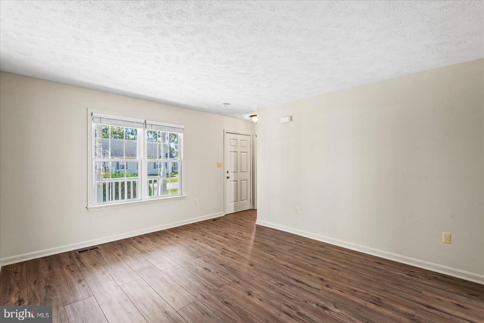 321 3rd Street Colonial Beach, VA 22443 - Photo 8 of 47 a view of an empty room with wooden floor and a window