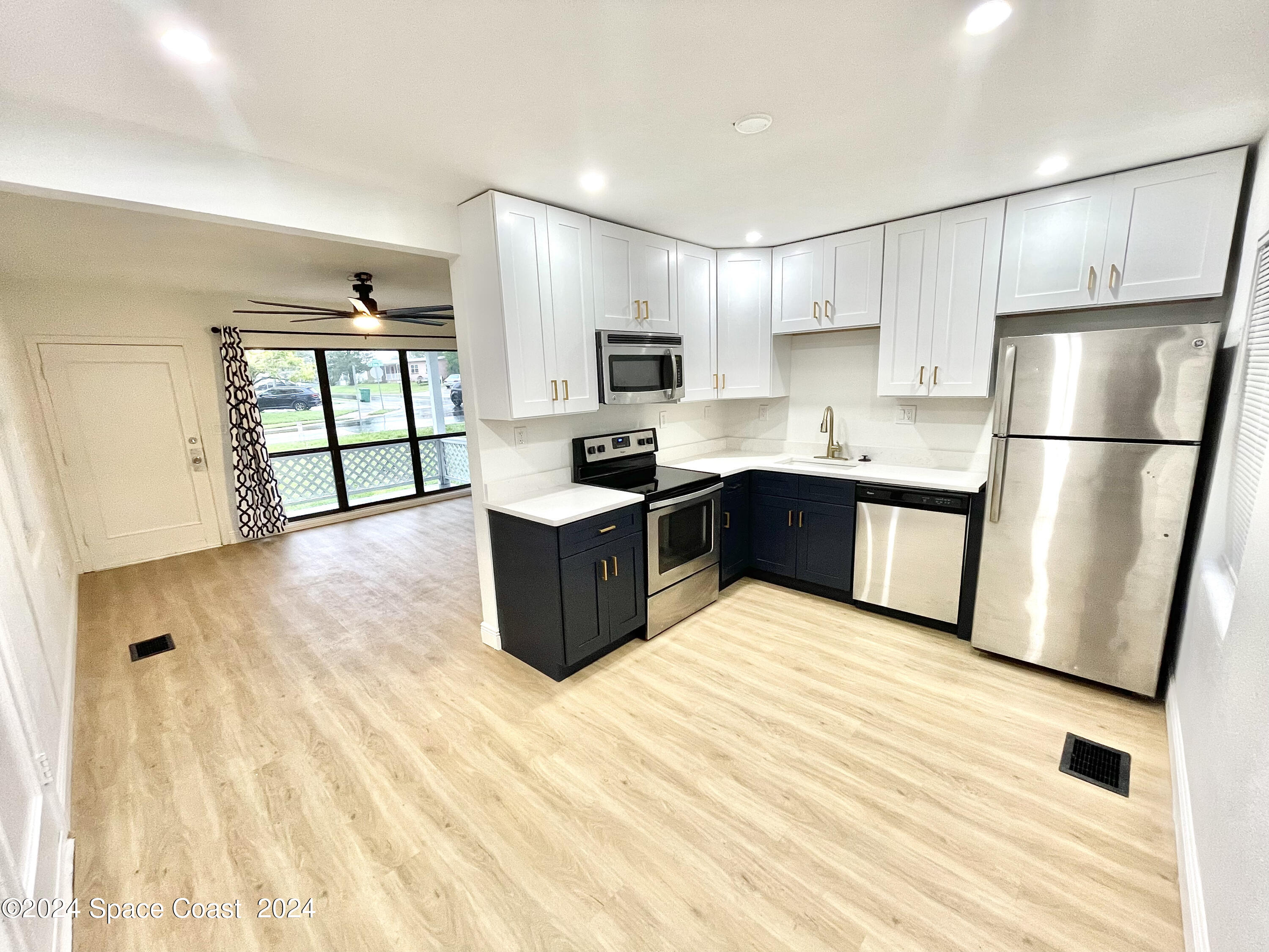 a large kitchen with stainless steel appliances granite countertop a stove a sink dishwasher and a refrigerator