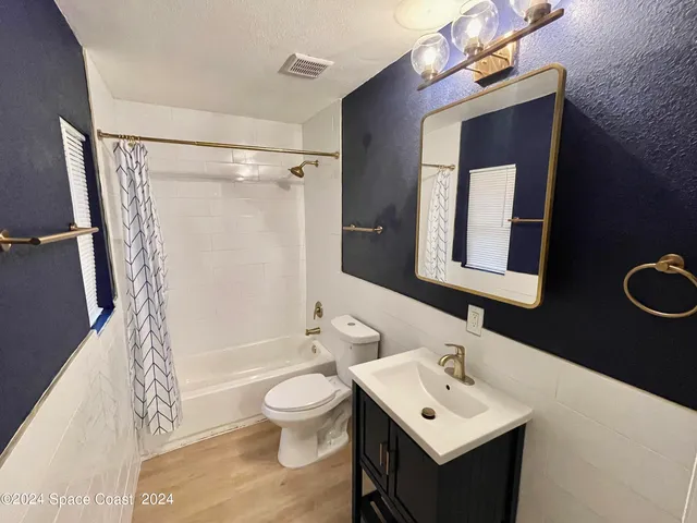 a bathroom with a sink mirror toilet and shower