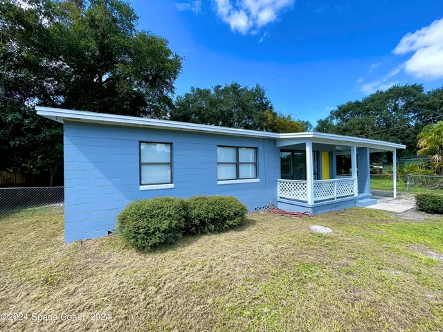 a view of a house with a yard in front of it