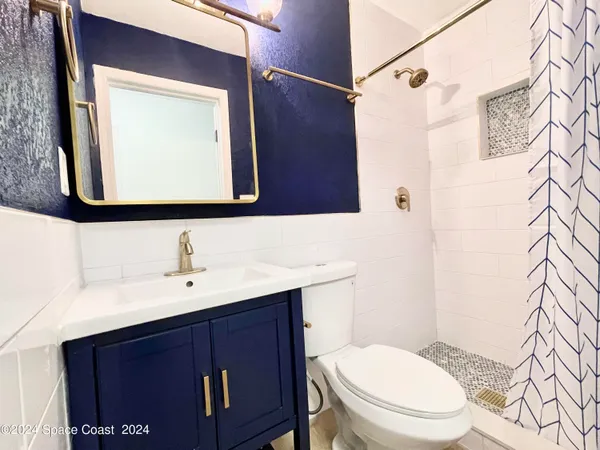 a bathroom with a toilet a sink and a mirror