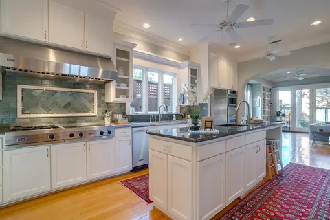 a large kitchen with stainless steel appliances lots of counter space and wooden floor