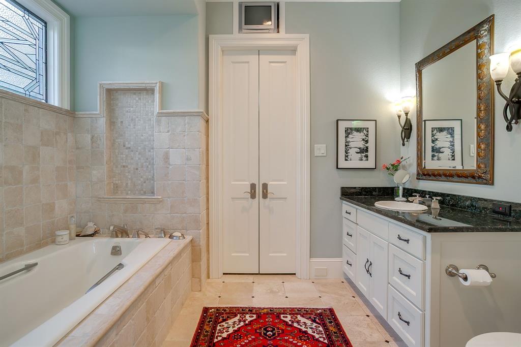 1620 Western Avenue Fort Worth, TX 76107 - Photo 27 of 40 a bathroom with a granite countertop sink a mirror a bathtub and shower