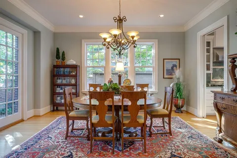 a dining room with furniture a chandelier and wooden floor