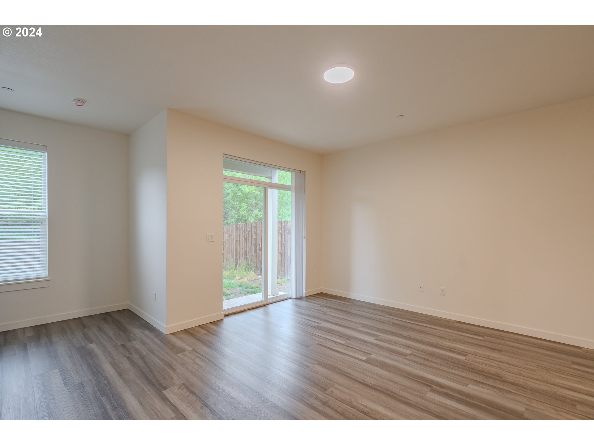 349 South 69th Place Ridgefield, WA 98642 - Photo 12 of 45 a view of an empty room with wooden floor and a window