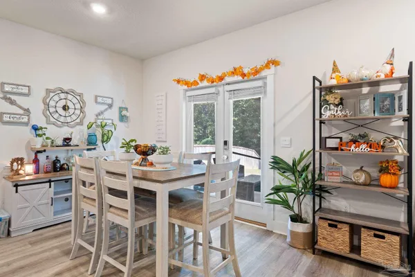 a dining room with furniture potted plants and wooden floor