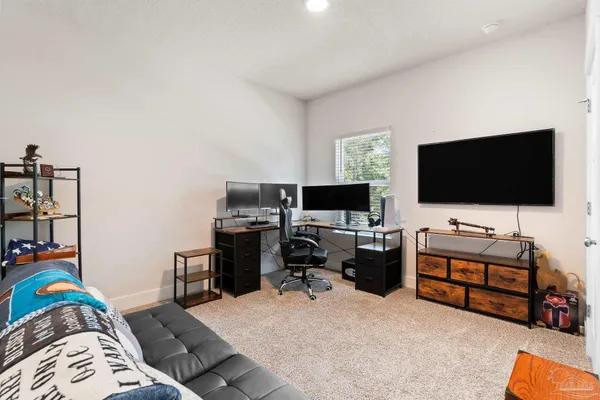 a view of a livingroom with workspace and a flat screen tv