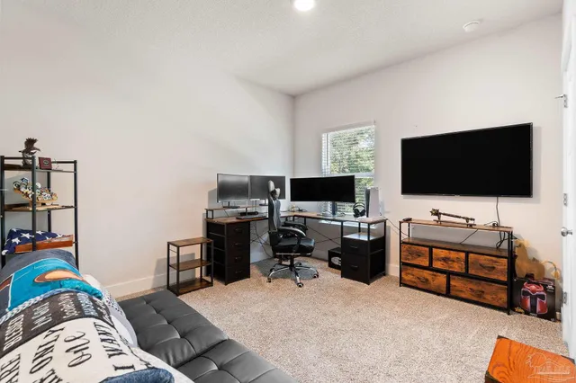 a view of a livingroom with workspace and a flat screen tv