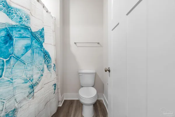 a white toilet sitting next to a shower curtain
