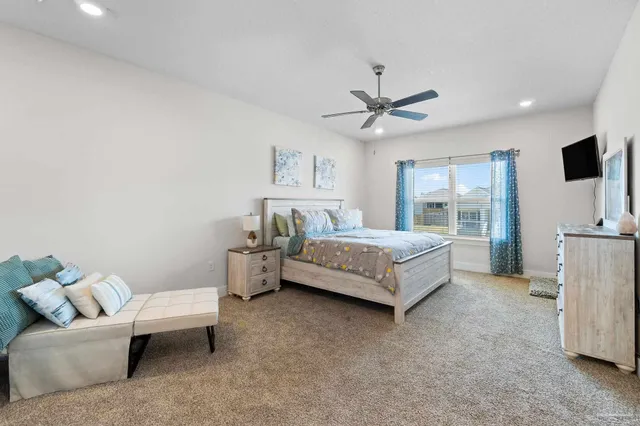 a bedroom with a bed couch and a large window