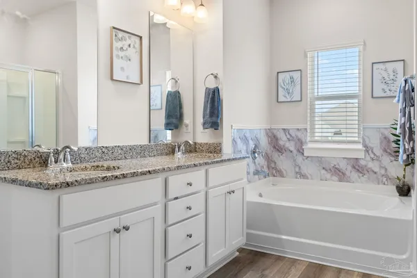 a bathroom with a granite countertop sink tub and a mirror