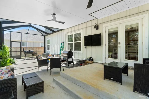 a living room with furniture flat screen tv and large window
