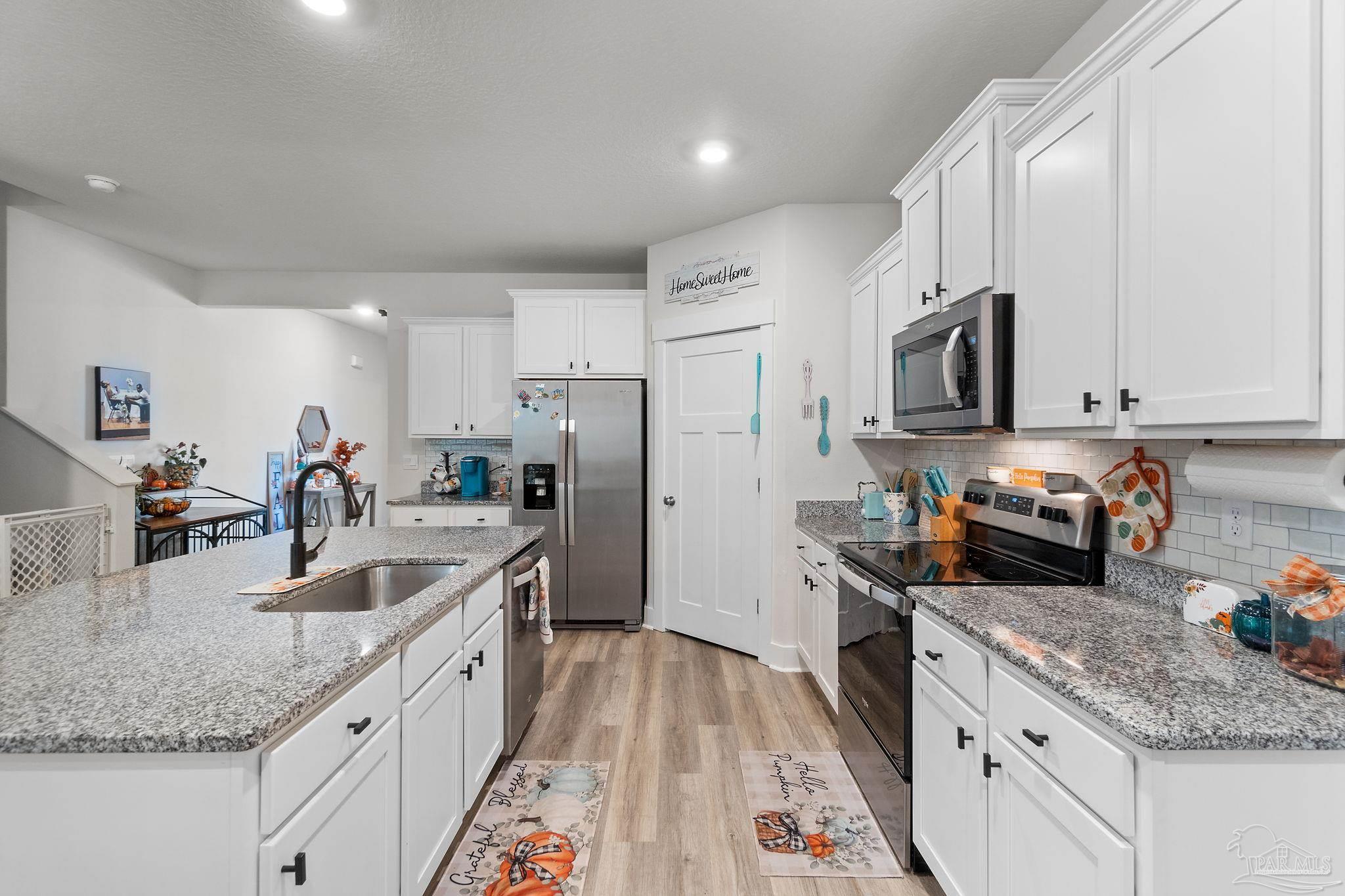 6060 Rutherford Loop Pensacola, FL 32526 - Photo 6 of 44 a kitchen with stainless steel appliances granite countertop a sink stove and refrigerator